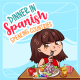 A cheerful illustration for "Dinner in Spanish Speaking Countries" featuring an animated girl with brown hair eating a salad, with an apple and a box of 'Naranja' juice on the table, against a backdrop with the logo of 'Kids Club - Spanish School'